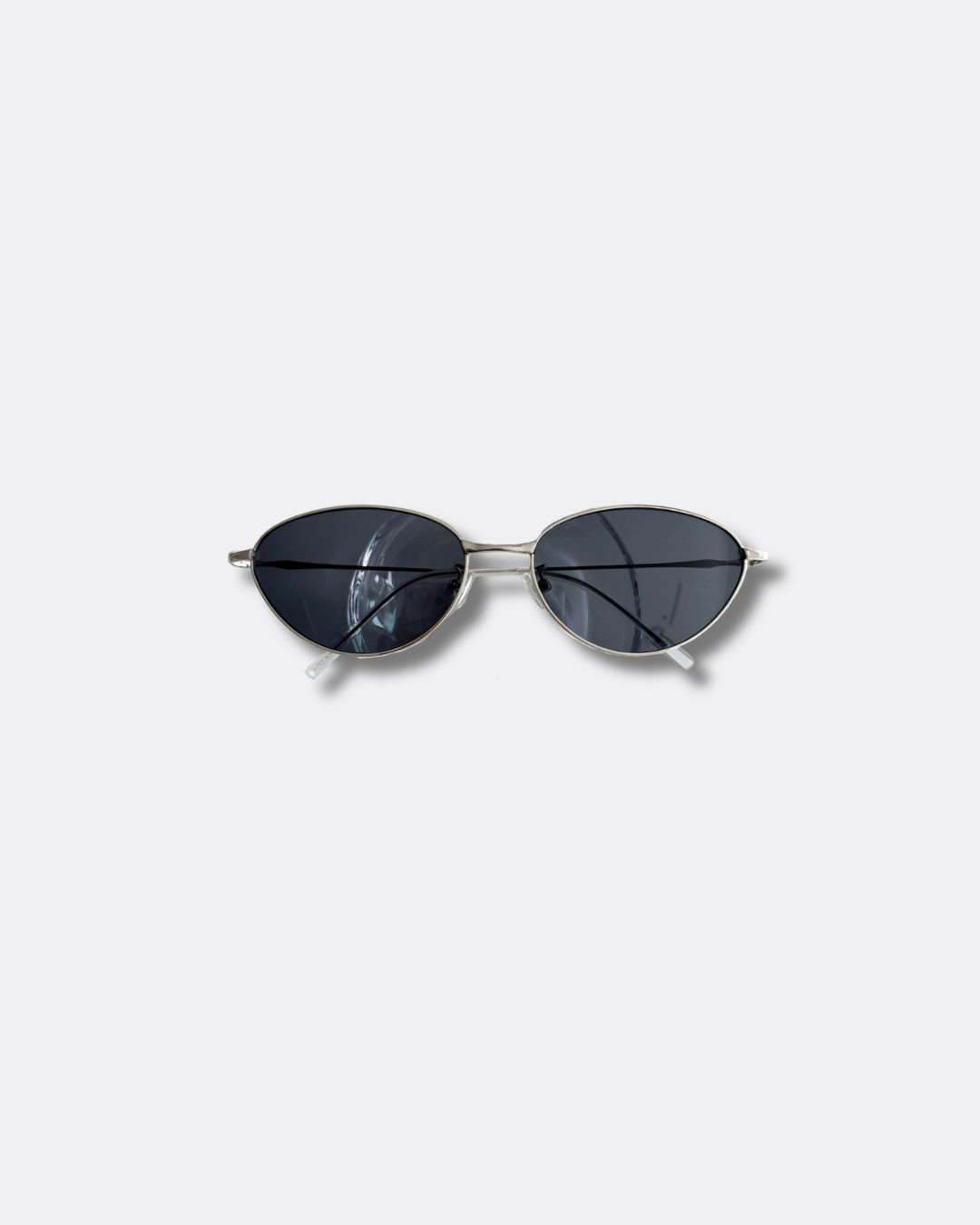 Sunglasses with dark lenses and thin frame on a light gray background