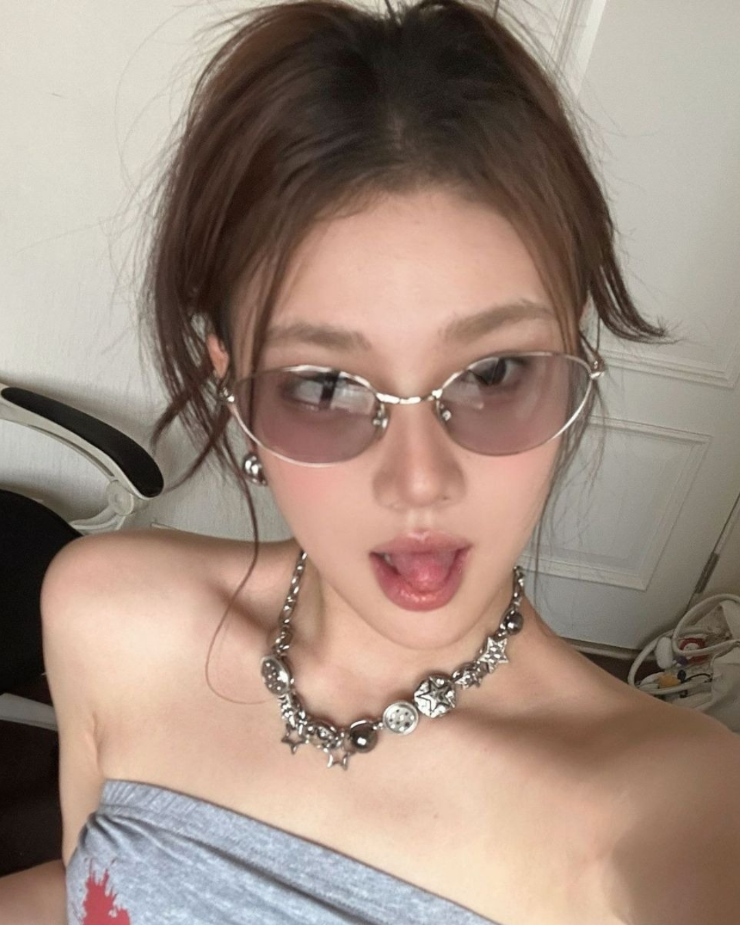 Person wearing sunglasses and a strapless top indoors