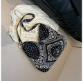 Black bandana with white patterns on a white surface