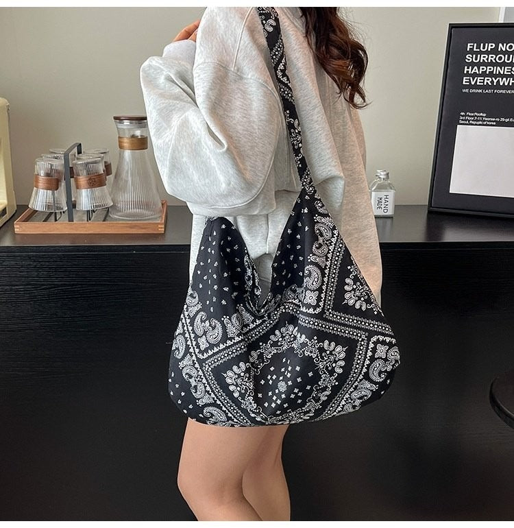 Person holding a black and white patterned bag in a casual setting