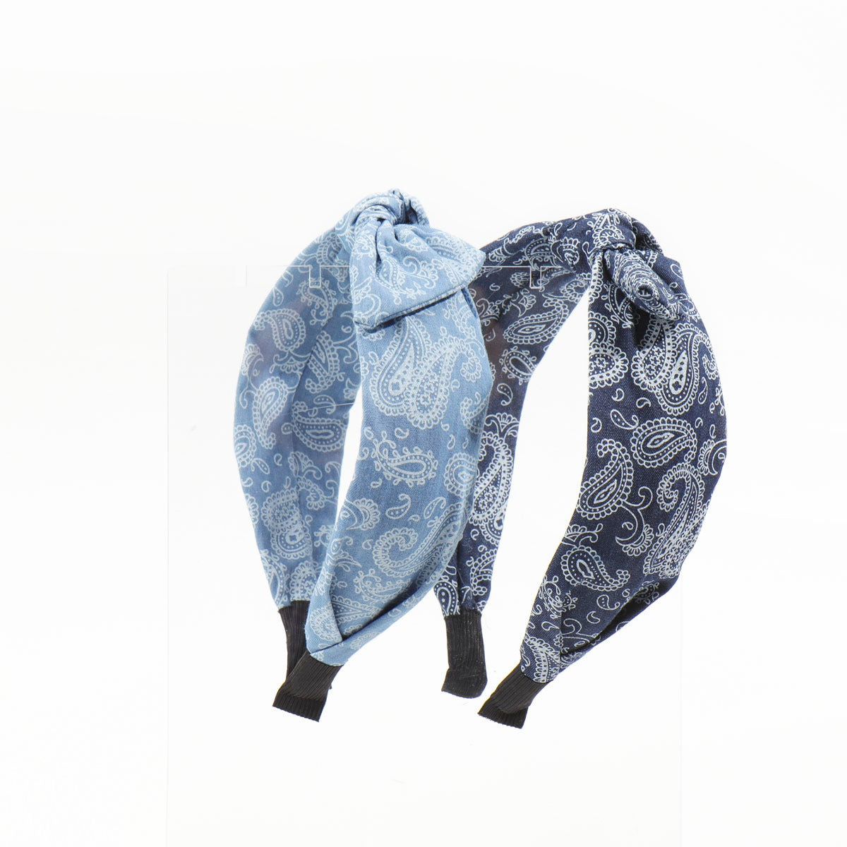 Two paisley bandana headbands, one light blue and one dark navy blue, displayed upright side-by-side on a clear acrylic stand.